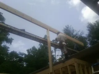 Carpenter setting a ridge beam over a new addition frame — Ice Dam Removal by Roofing Brothers in Red Hook