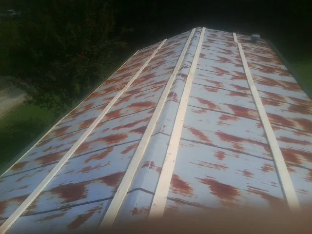 Rusted metal roof panels with new wood purlins before replacement — Storm Damage Roof Repair in Red Hook by Roofing Brothers