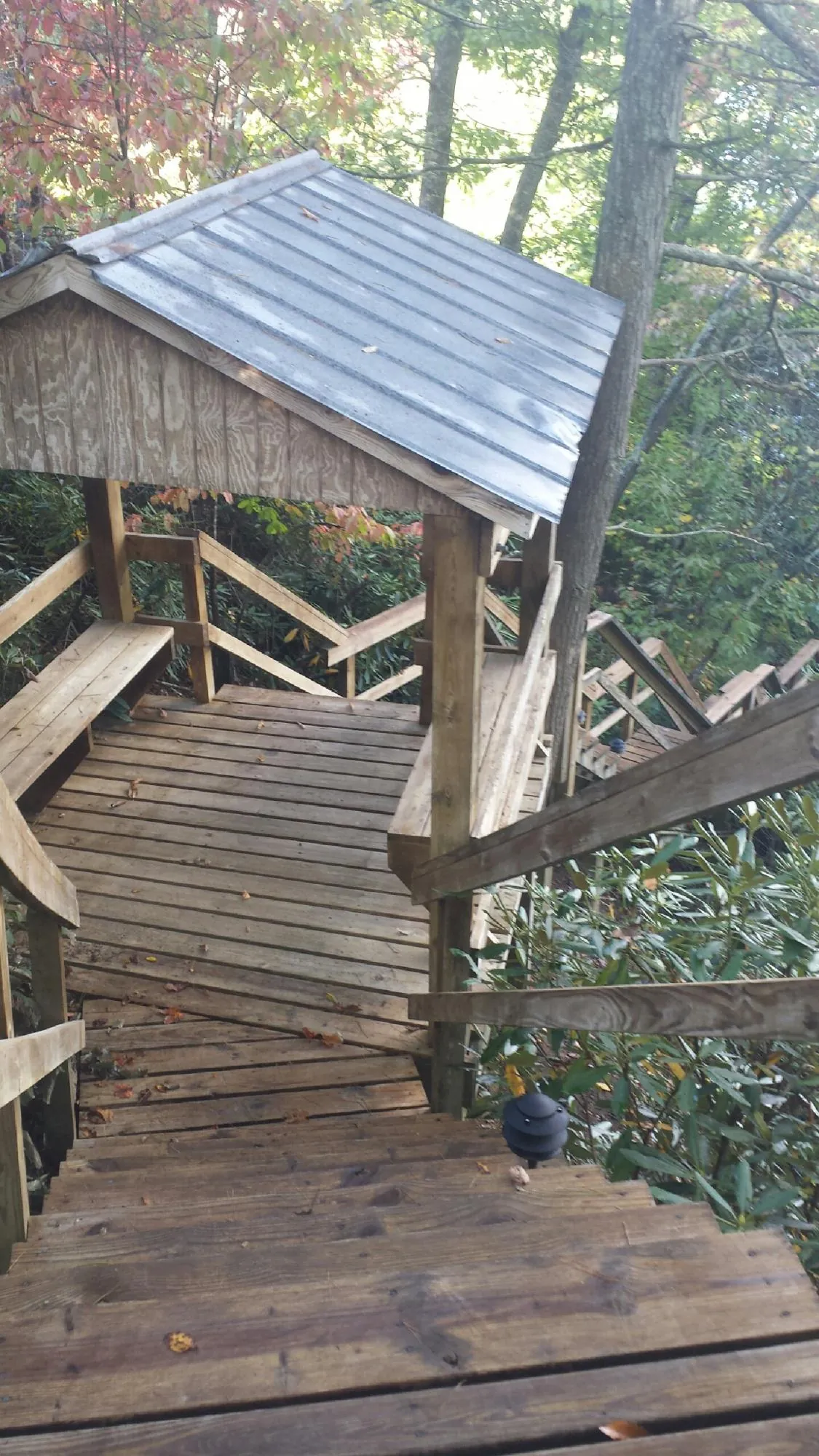 Metal roofed shelter over wooden steps on a wooded walkway — Skylight Repair & Installation work by our crew in Red Hook